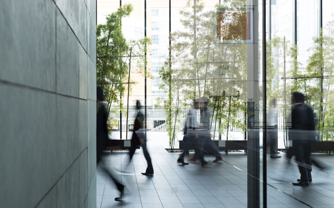 Corporate professionals walking purposefully in a modern urban office building, symbolizing dynamic business culture