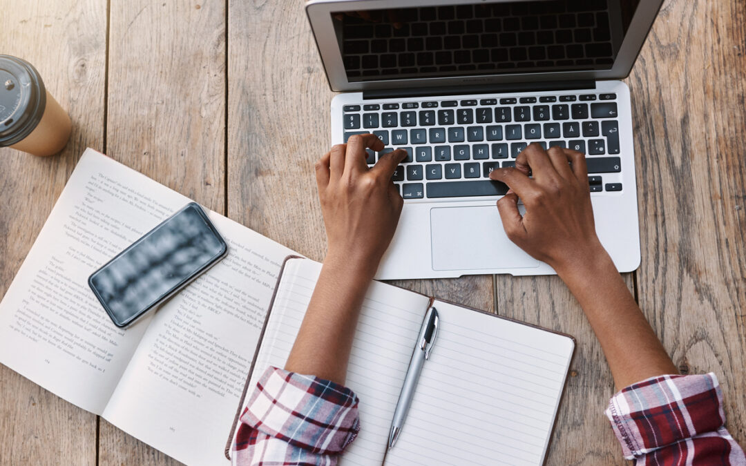 High angle shot of an unrecognizable female remote worker using her laptop while sitting outside on at home.
